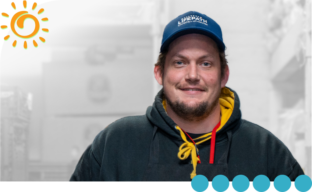 This is John. He's smiling and wearing a baseball cap and a sweatshirt.